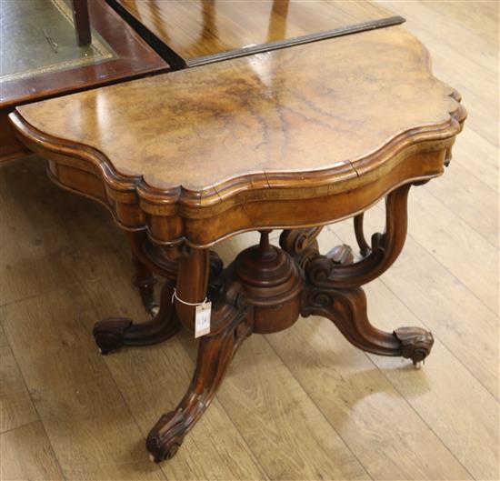 A Victorian figured walnut shaped topped folding card table on a globe base W.91cm